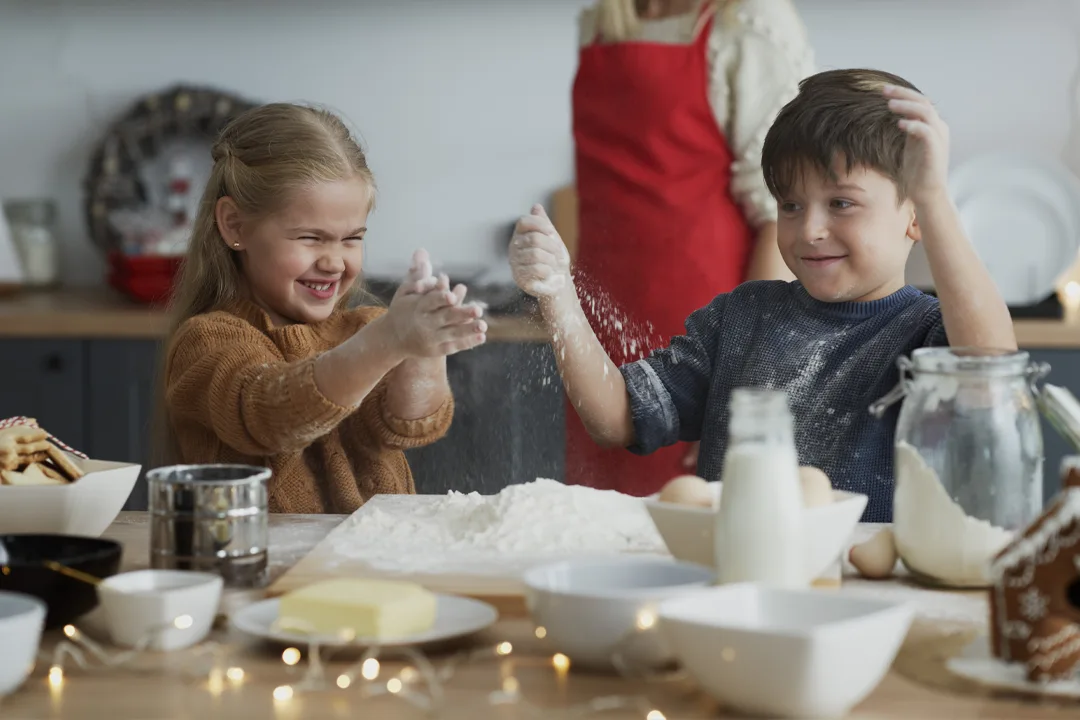 کودک در حال کار با غذاساز در کنار مادر